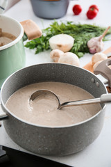 Pot with delicious cream soup on white table