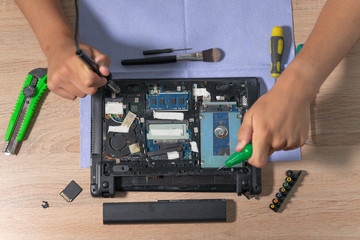 Engineer fixing broken computer at work. Electronic repair shop. Computer maintenance