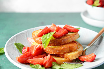 Tasty French toasts and strawberry on plate