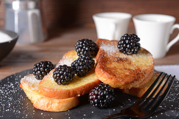 Tasty French toasts and blackberry on slate plate, closeup