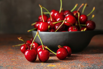 Bowl with sweet ripe cherry on grunge table