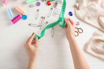 Female hands with measuring tape and accessories on white background