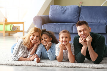 Happy couple with little adopted children at home