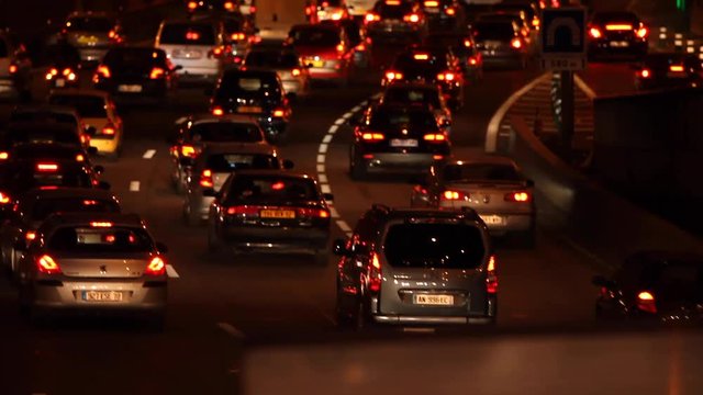 Paris, France - April 6, 2019: Car Traffic by night at Paris Parc Des Princes soccer stadium taken from bridge view. Lights, cars, fires, trees, bus, blur effect. Lot of vehicles. Blurred Tight Shot.