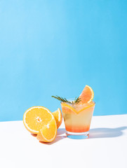 Cold and refreshing orange punch cocktail with orange slice on color background. summer drink.
