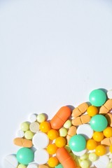 background with white, yellow, orange and green pills on a white background with space for text