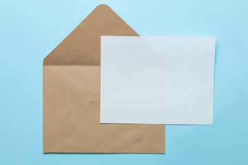 Craft envelope and blank for text on a bright trendy light blue background. top view