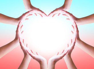 International Day of Friendship concept: hands in shape of heart on blurred  background