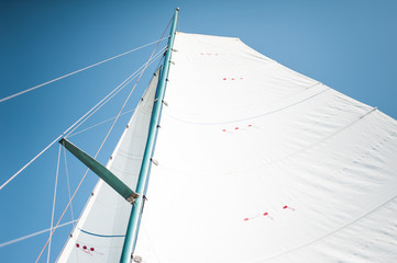 White cloth fabric, masts and ropes close-up on the sail of tri-yacht or yacht sailing boat