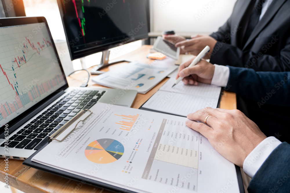 Poster team of stockbrokers discussing with display screens analyzing data, graphs and reports of stock mar