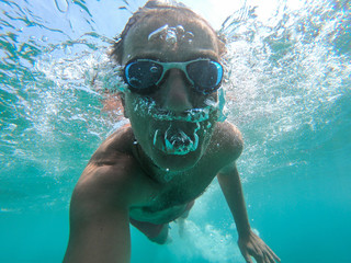 Naklejka premium Underwater selfie shot of a swimmer in the sea