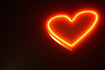 Little blured neon heart on black background. Valentin's day concept.