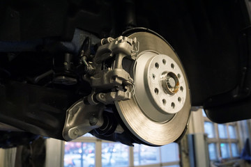 Brake disc and brake caliper on a modern car. Repair and maintenance of a modern car.