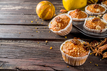 Homemade Autumn Pumpkin Spice Muffins with Pecan nuts. Fall and winter baking. Old rustic wooden background copy space.