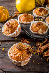 Homemade Autumn Pumpkin Spice Muffins with Pecan nuts. Fall and winter baking. Old rustic wooden background copy space.