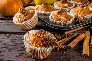 Homemade Autumn Pumpkin Spice Muffins with Pecan nuts. Fall and winter baking. Old rustic wooden background copy space.