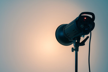 Studio light on the stand. Spotlight on white wall background. C