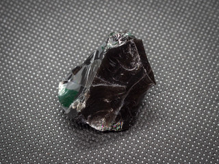 Geological specimen of natural black layered mineral obsidian (aka volcanic glass or dragonglass)...