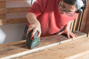 woman sanding a restored wood
