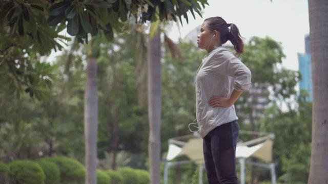 Attractive caucasian asian girl warming up to run. Sport woman stretching before running workout.
