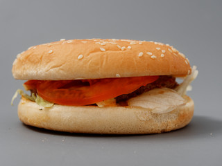 big burger with cutlet cheese tomato cabbage on gray background