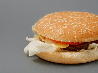 big burger with cutlet cheese tomato cabbage on gray background