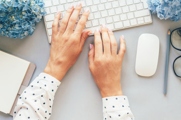 Office concept, top view of hands in a polka-dot shirt typing on a computer keyboard, fashionable business lady blogger keeps her blog on the website. Modern society and the way of communication. 