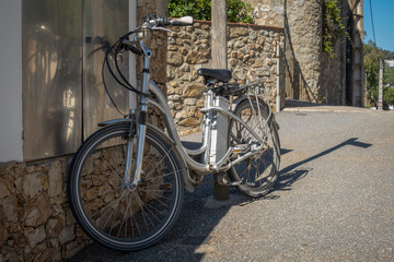 electric bicycle leaning on a wall in a mediterranean village