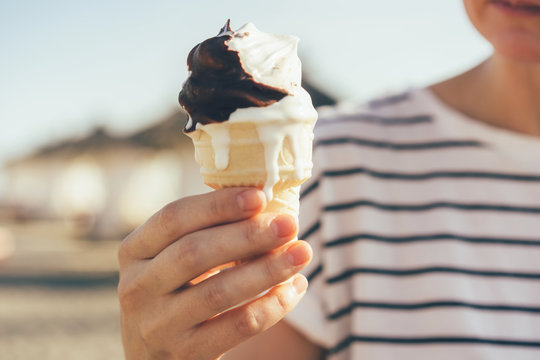 Closeup Of Hand Holding Melting Ice Cream In Cone