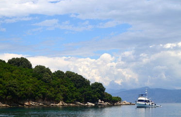 Fototapeta premium Lonely sailboat in the sea and mountain forests