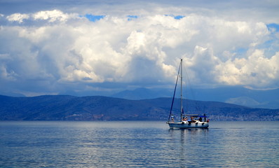 Lonely sailboat in the sea and mountain forests