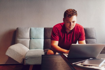 Young handsome male 20 years old in eyeglasses sitting at street cafe during free time with new modern laptop, bearded man freelancer thoughtfully looking aside and thinking about distance work