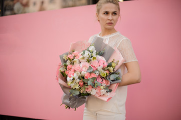 Young girl hold bouquet in gray and pink paper