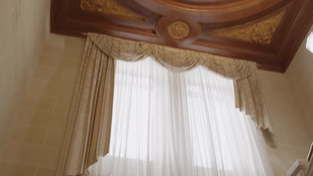 Beautiful huge clock in brown, yellow and green solid wood with five dials on the ceiling of a large castle.