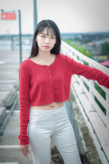 portrait Asian woman wearing casual red long-sleeved t-shirt in park.