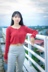 portrait Asian woman wearing casual red long-sleeved t-shirt in park.