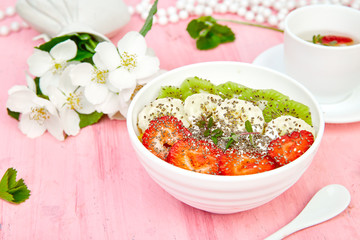 Healthy breakfast bowl smoothie with strawberry, banana, kiwi  and chia seeds on pink background. Healthy vegan food concept..