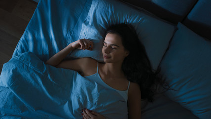 Top View of Beautiful Young Woman Sleeping Cozily on a Bed in His Bedroom at Night. Blue Nightly...