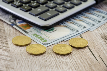 calculator with dollars and coins close up