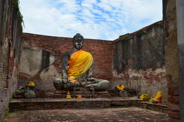 Thai culture Ayutthaya in Thailand, the ruins of an ancient temple with a portal and sculptures of buddhas, bricks