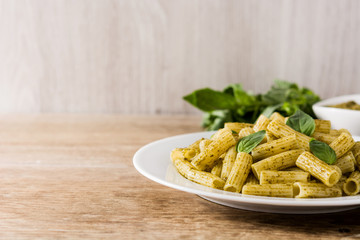 Penne pasta with pesto sauce on wooden table. Copyspace