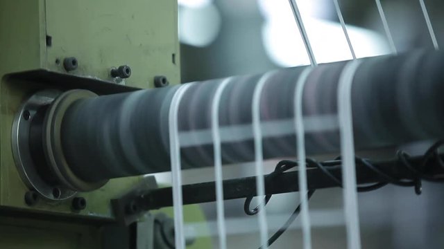 Label Shapes Printing Rolls with High speed labeling machine in industrial factory, sticker on product in manufacture. Flexible packaging. Close Up Tilt Up.