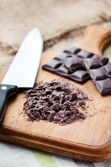 Chopped dark chocolate on wooden cutting board