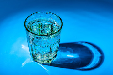 glass of water on a table  on a dark background