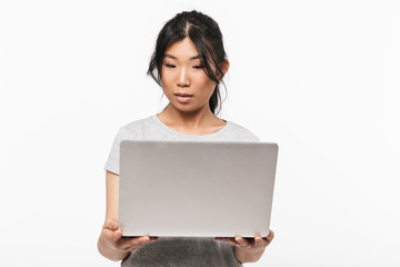 Naklejka premium Asian beautiful young woman posing isolated over white wall background using laptop computer.