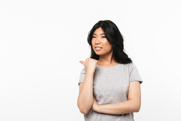 Obraz premium Beautiful young woman posing isolated over white wall background pointing.