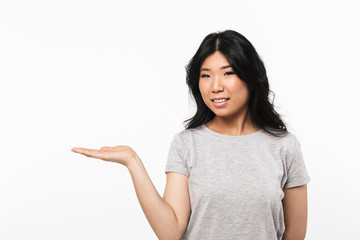 Beautiful young woman posing isolated over white wall background showing copyspace.