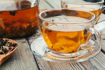 Cup of tea and tea leaves on wooden table