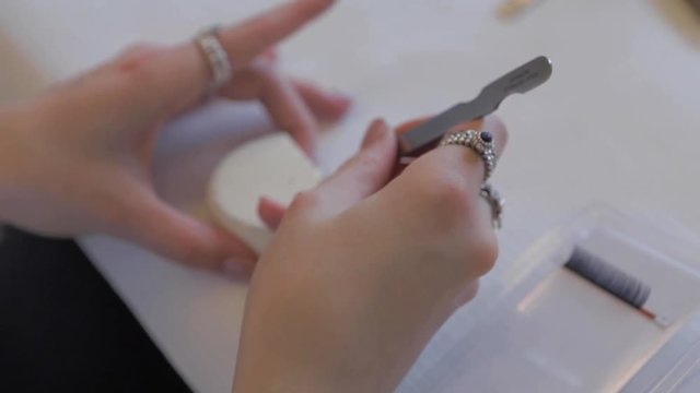Woman training on lashes extensions with glue during a conference on eyelash extensions in Prague. Eyelash extensions, lash process.