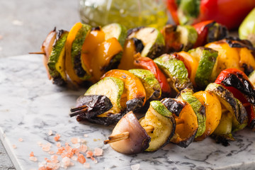Grilled vegetable skewers on the gray stone background